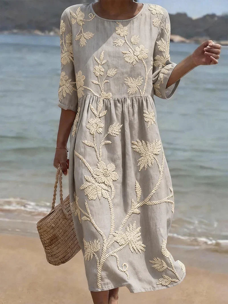 Back view of embroidered floral midi dress with continued embroidery pattern throughout