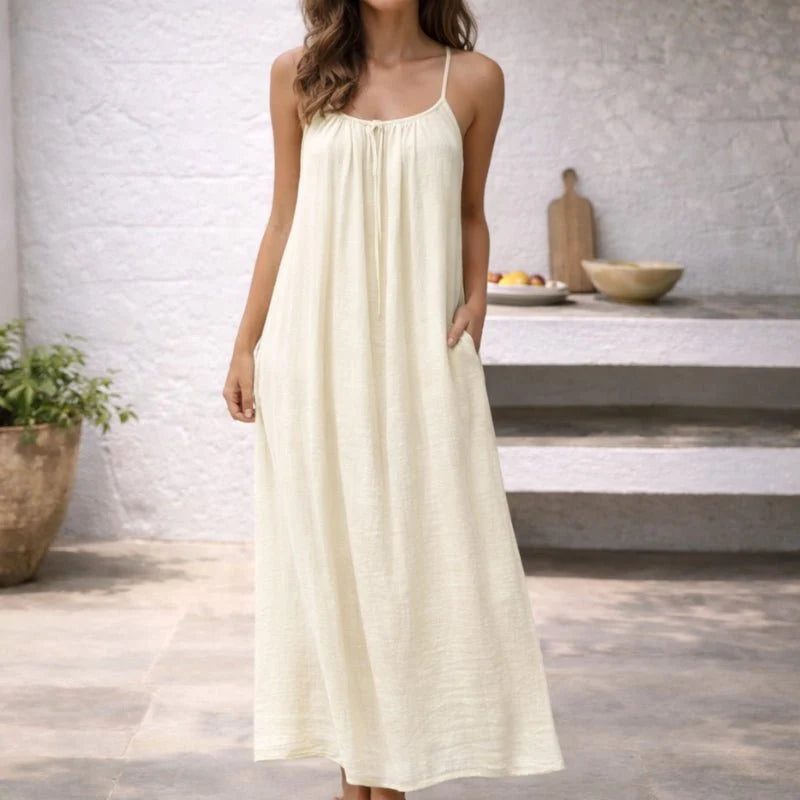 Floor-length dress with thin straps and discreet pockets in flowing white fabric