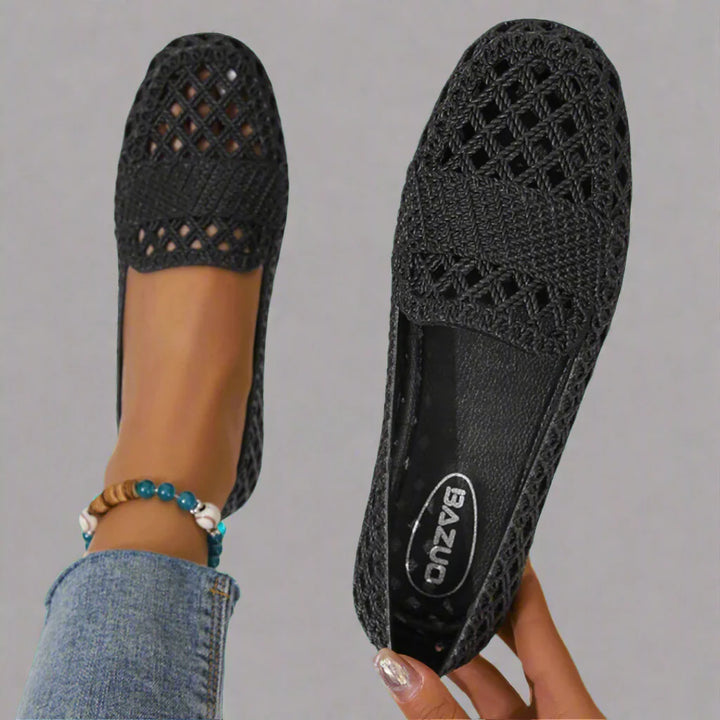 Side view of beige crochet espadrille flats with flat sole and rounded toe paired with denim jeans