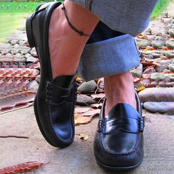 Side view of women's leather loafers showing structured sole and traditional stitched detailing for timeless style