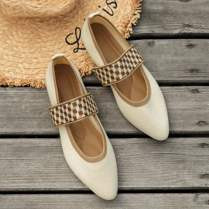 Women's Mary Jane flats in beige with checkered strap detail, displayed on wooden surface