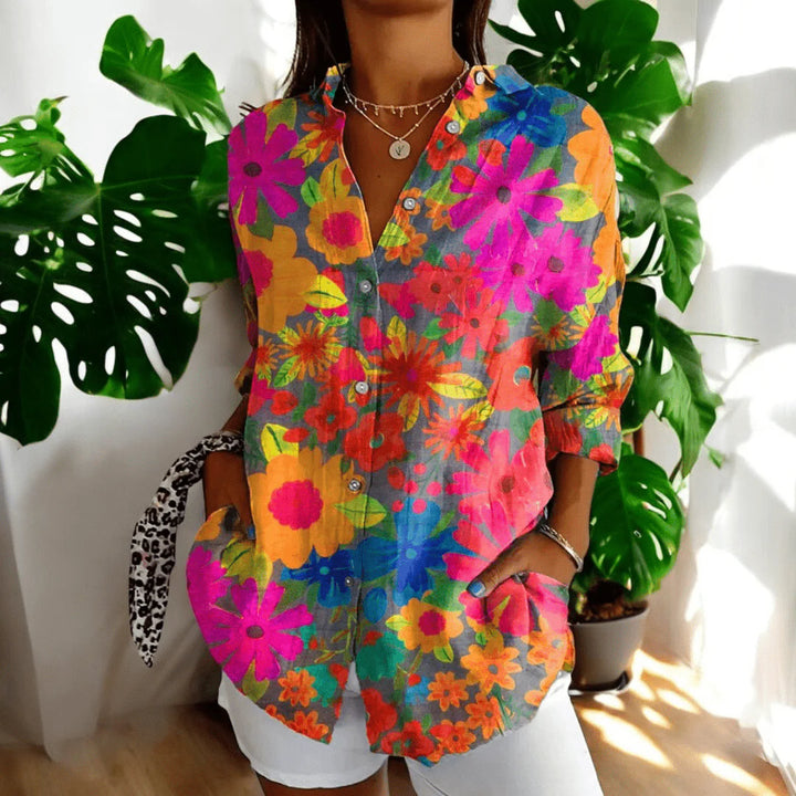 Women's floral print blouse showing vibrant pink and coral hibiscus pattern detail