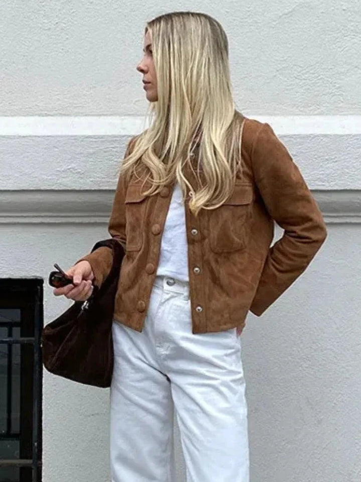 Women's tan suede jacket styled with casual denim trousers and white top