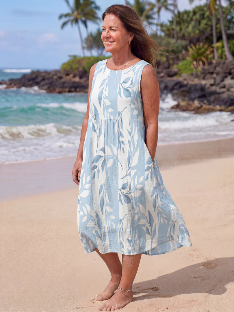 Close-up view of the botanical print pattern and gathered waist detail on a sleeveless midi dress.
