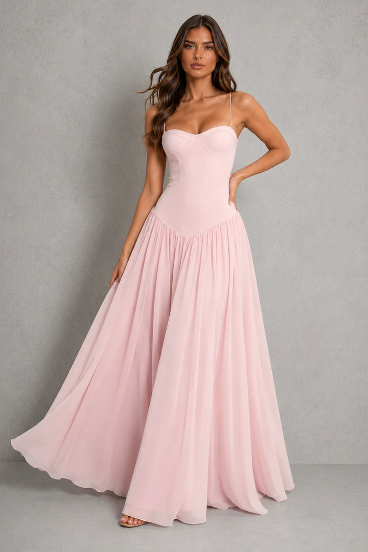 Strapless corset maxi dress in blush pink with structured bodice and flowing full-length skirt for wedding guest and evening occasions