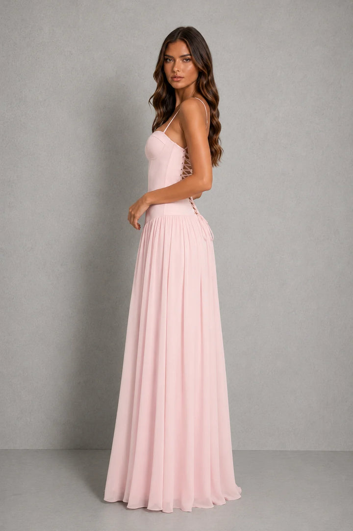 Side profile of strapless corset maxi dress showing fitted waist and graceful drape of full-length flowing skirt