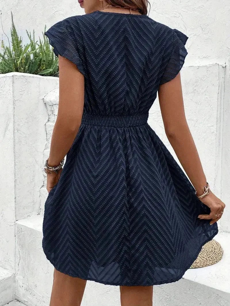 Detail shot of contrast crochet lace trim at waistband on textured dress