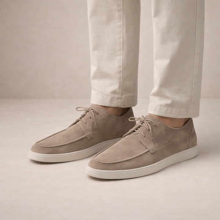 Men's lace-up moc-toe shoes in taupe, worn on model with cream trousers
