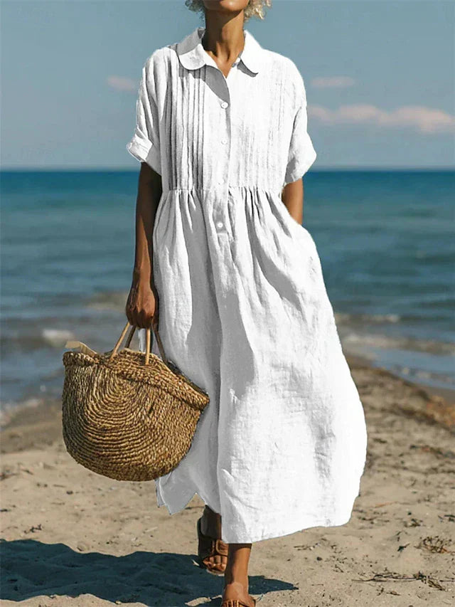 Woman wearing white collared button midi dress with gathered waist on beach