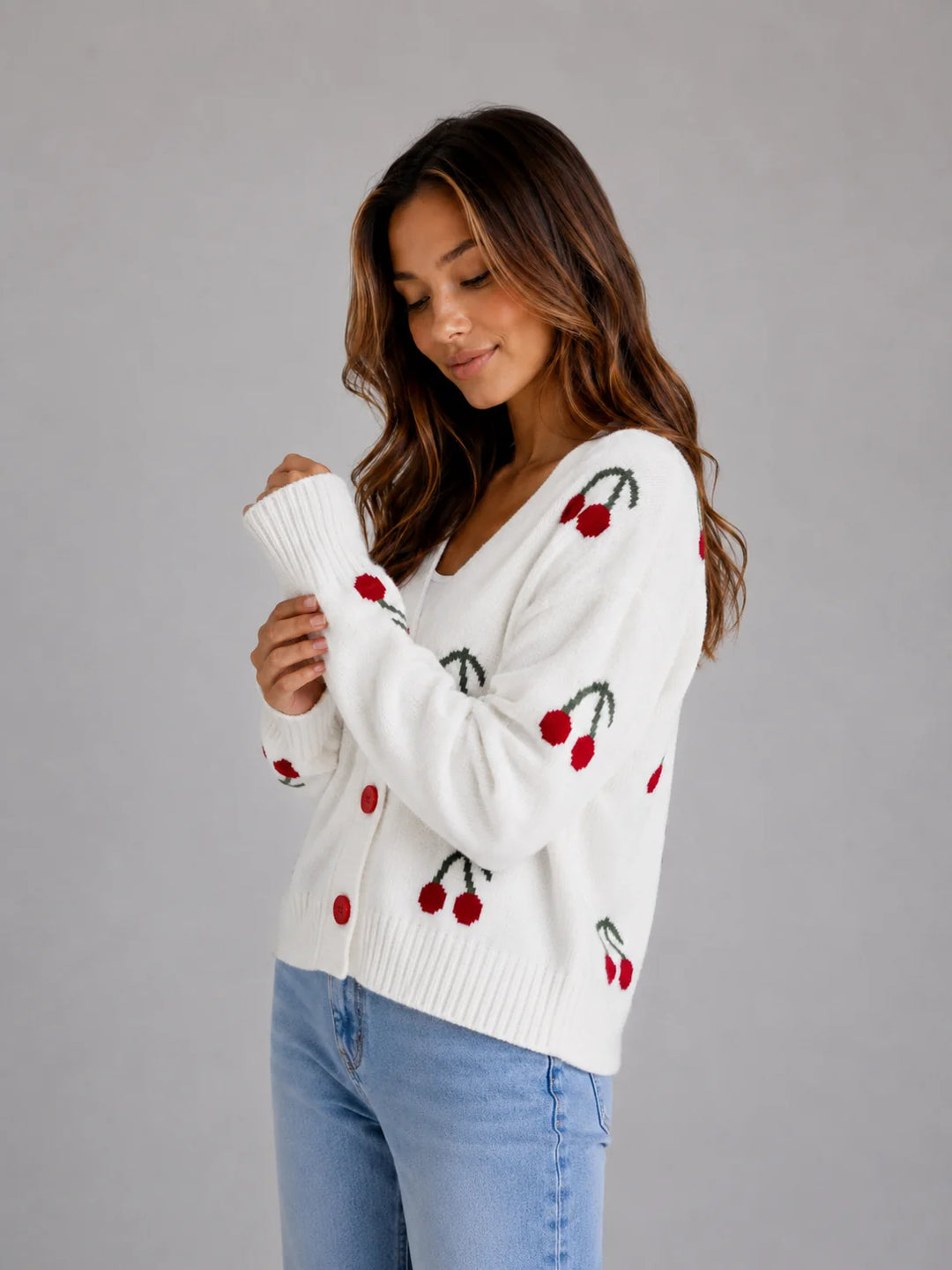 Detail of cherry print pattern on women's button front cardigan with ribbed cuffs