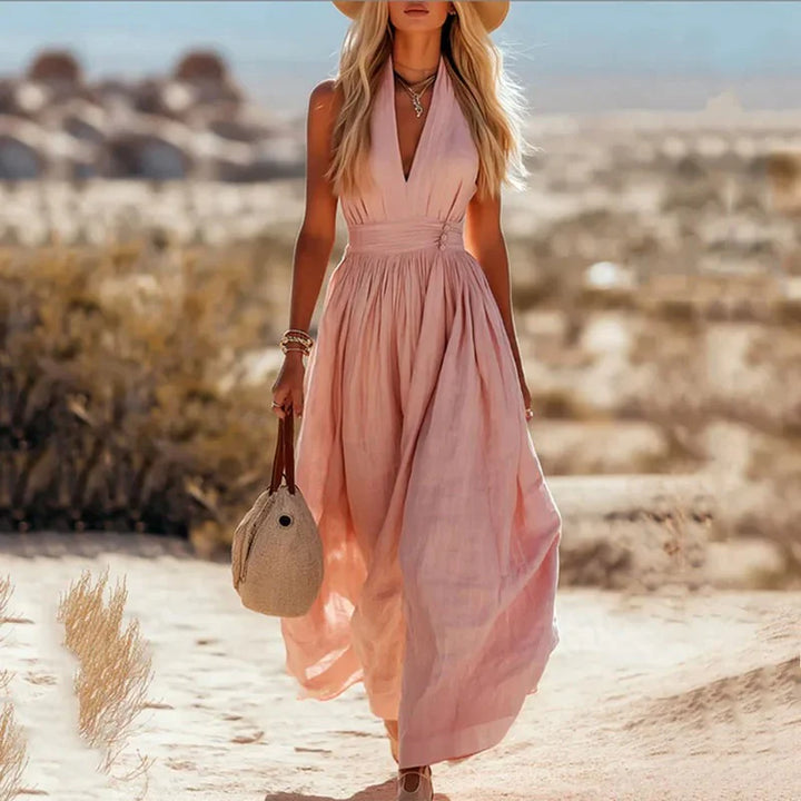 Flowing halter neck maxi dress in warm taupe, styled for beach occasions