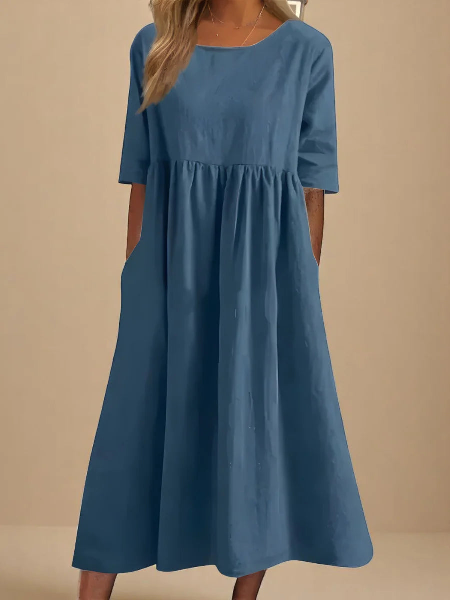 Relaxed midi dress with round neckline, mid-length sleeves, and flowing A-line skirt with side pockets in blue