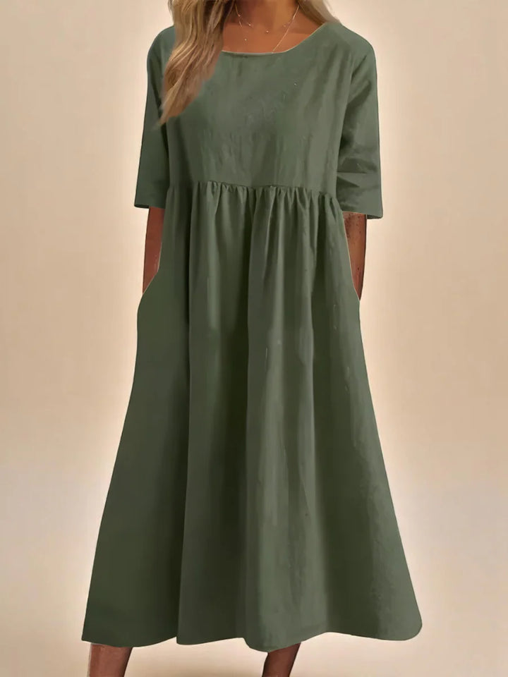 Close-up of round neckline and mid-length sleeves on relaxed midi dress