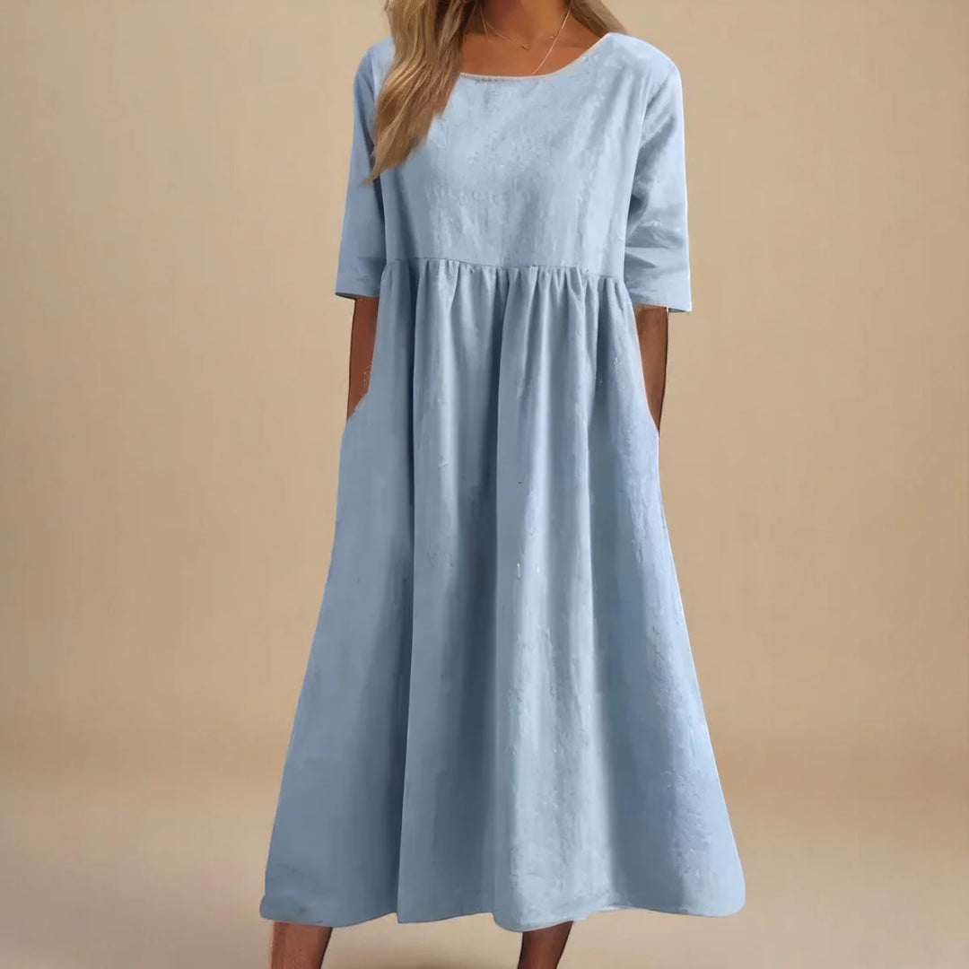 Detail of flowing midi-length skirt on relaxed dress with breathable woven fabric