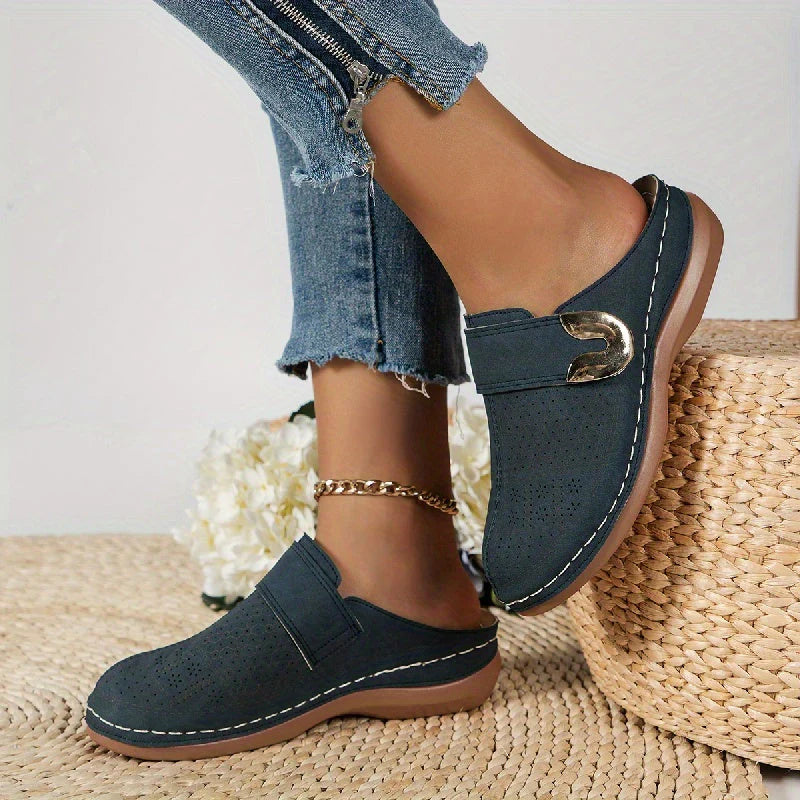 Women's slip-on mules from rear angle showing open-back design and rubber sole