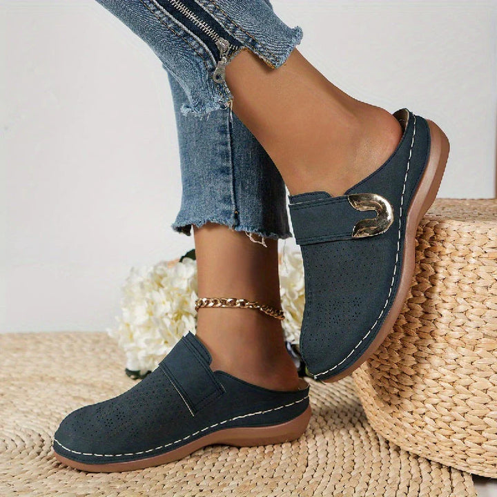 Women's slip-on mules from rear angle showing open-back design and rubber sole