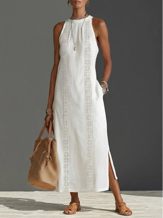 Woman wearing white embroidered sleeveless midi dress with intricate front panels and round neckline