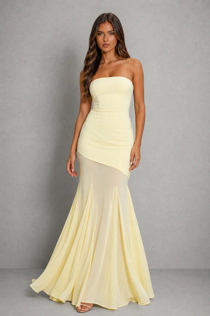 Side view of strapless maxi dress showing asymmetric hem detail and flowing sheer overlay with mini-length lining beneath