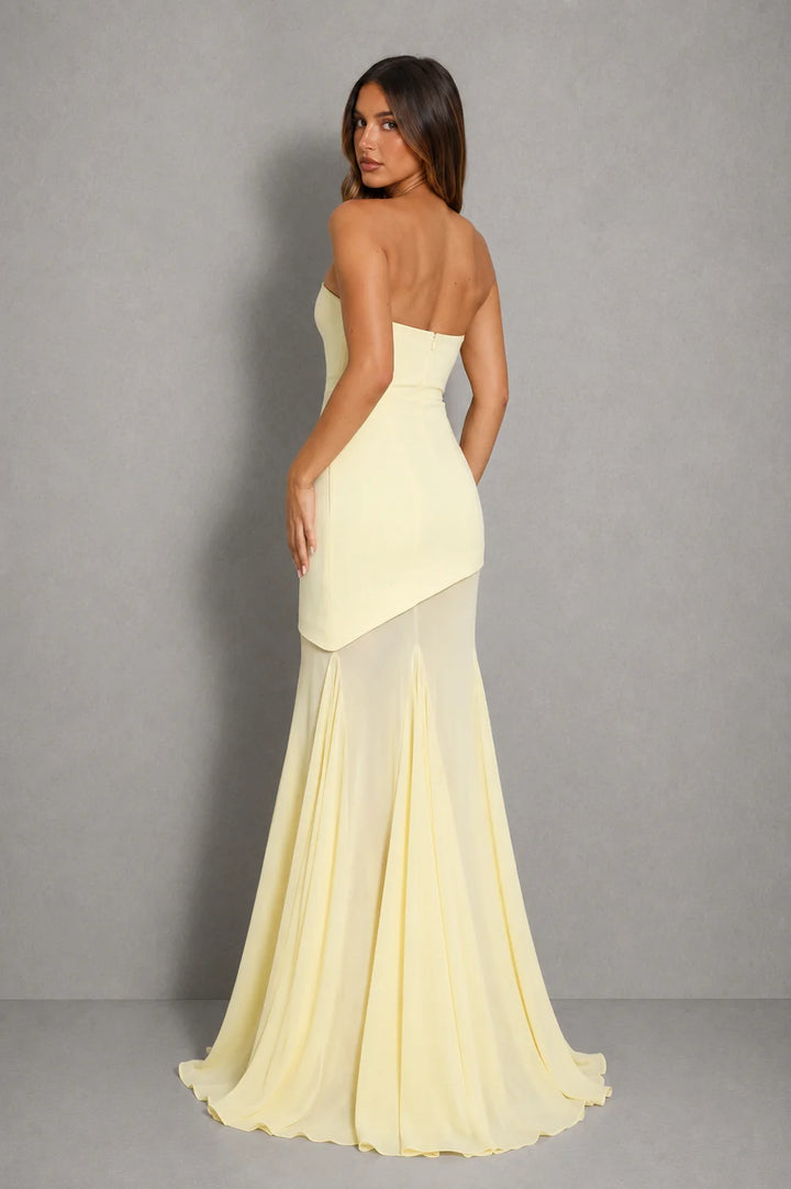 Full-length view of women's evening dress with sheer maxi overlay and asymmetric hem in pale yellow