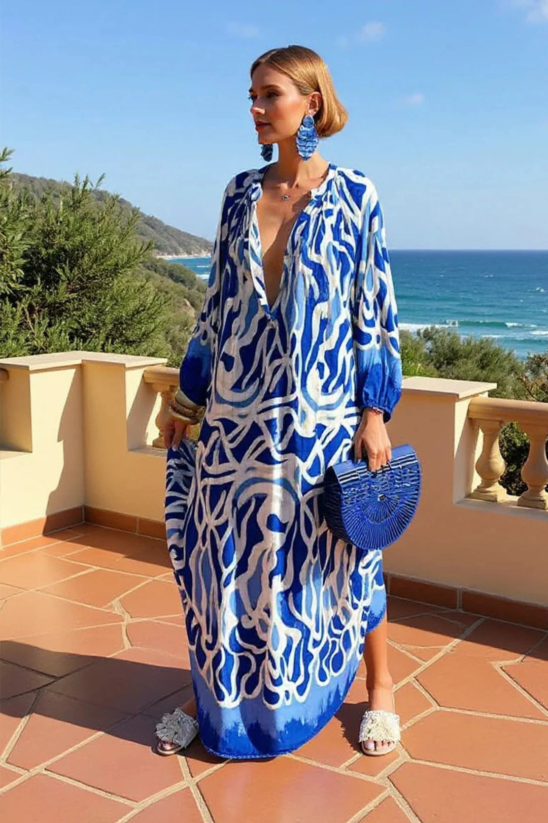 Close-up of abstract print kaftan dress showing gathered tie detail at V-neckline and artistic swirl pattern