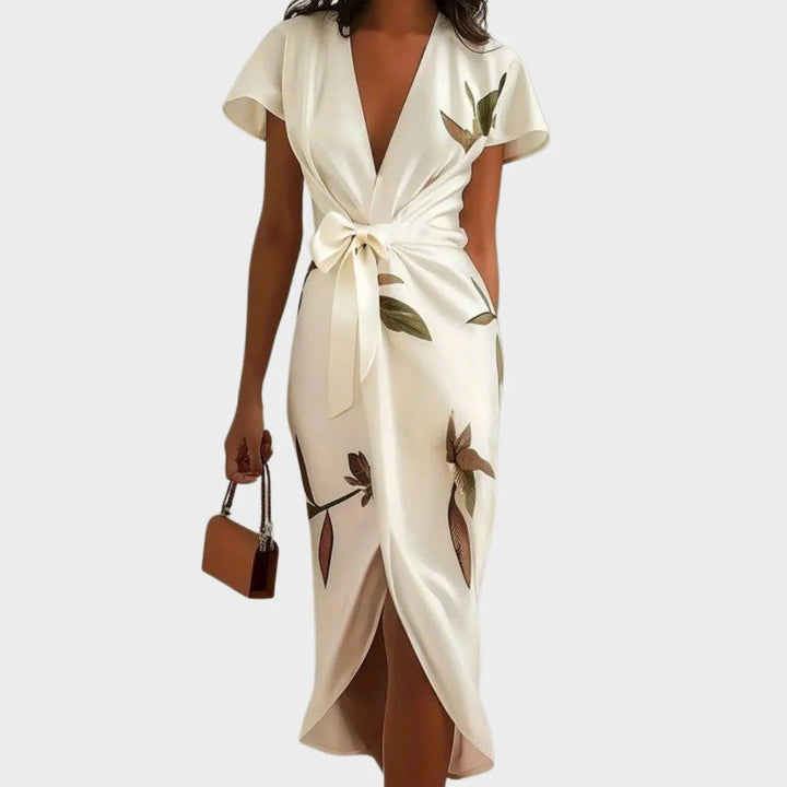 Floral wrap midi dress with botanical leaf print and tie waist detail on cream background