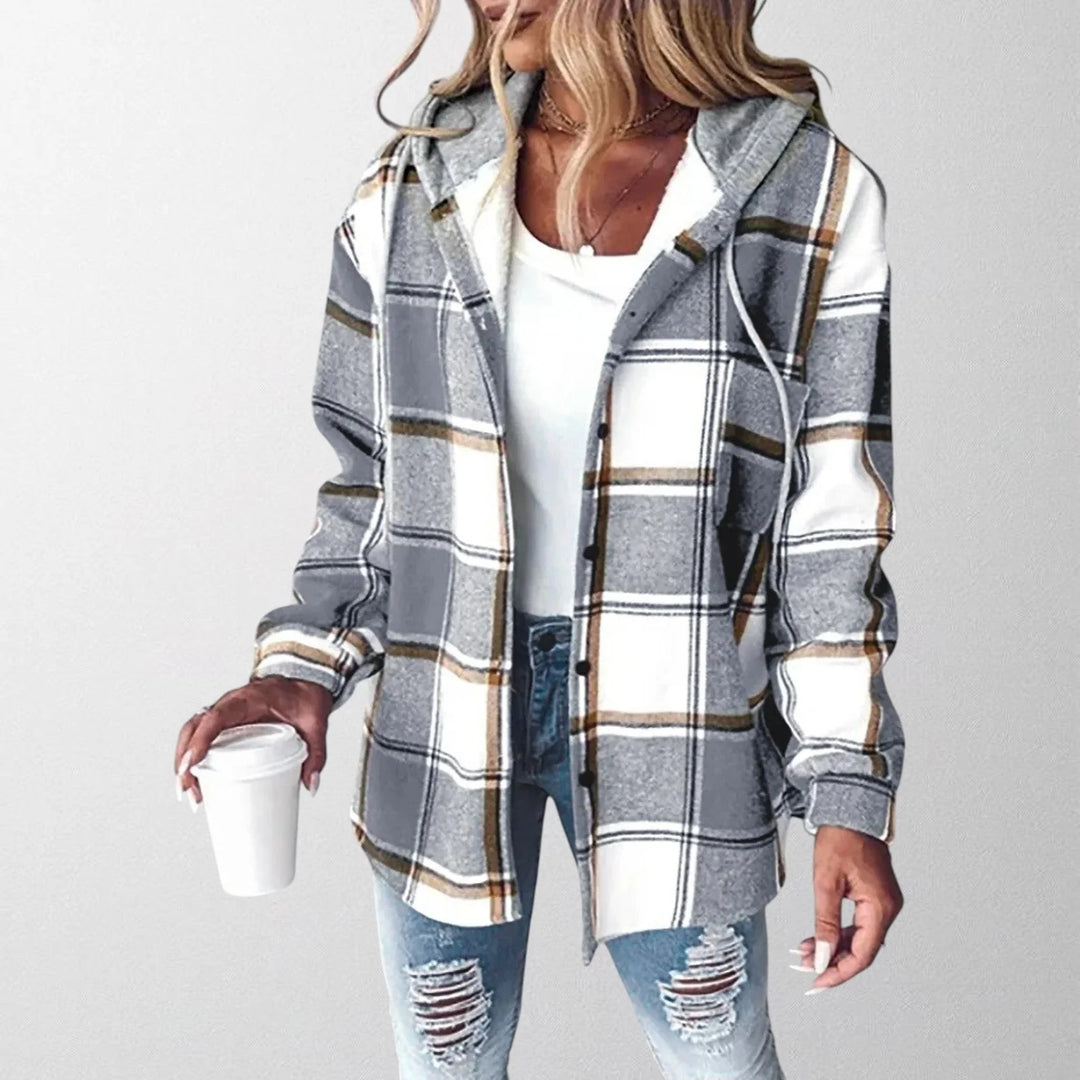 Woman wearing grey and white check warm stylish jacket with hood over white tee and distressed jeans
