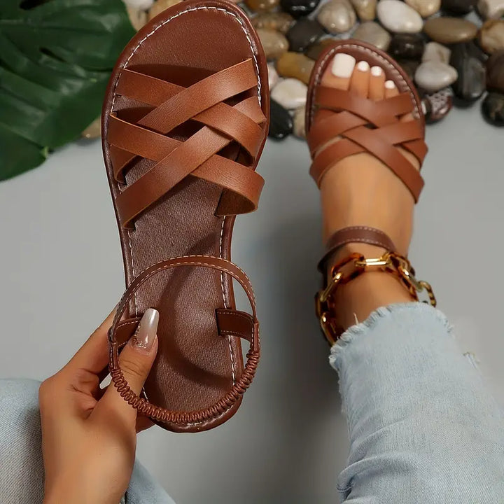 Side view of women's strappy sandals displaying elasticated ankle strap and flat sole construction