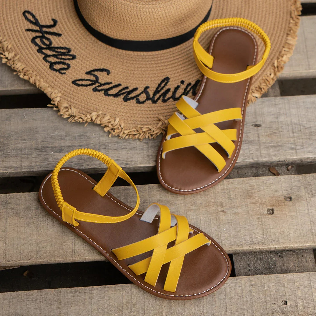Detail shot of women's flat sandals showing elasticated ankle strap mechanism and contrast stitching