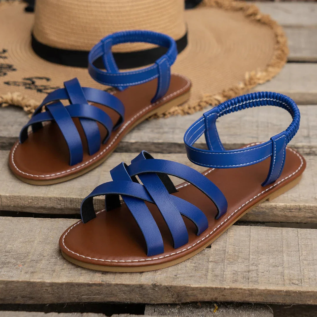 Women's strappy flat sandals displayed from multiple angles showing crossover straps and flat sole design
