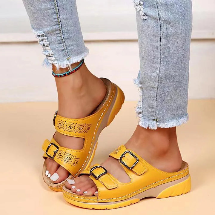 Top view of women's buckle slide sandals displaying perforated pattern and adjustable strap placement across foot