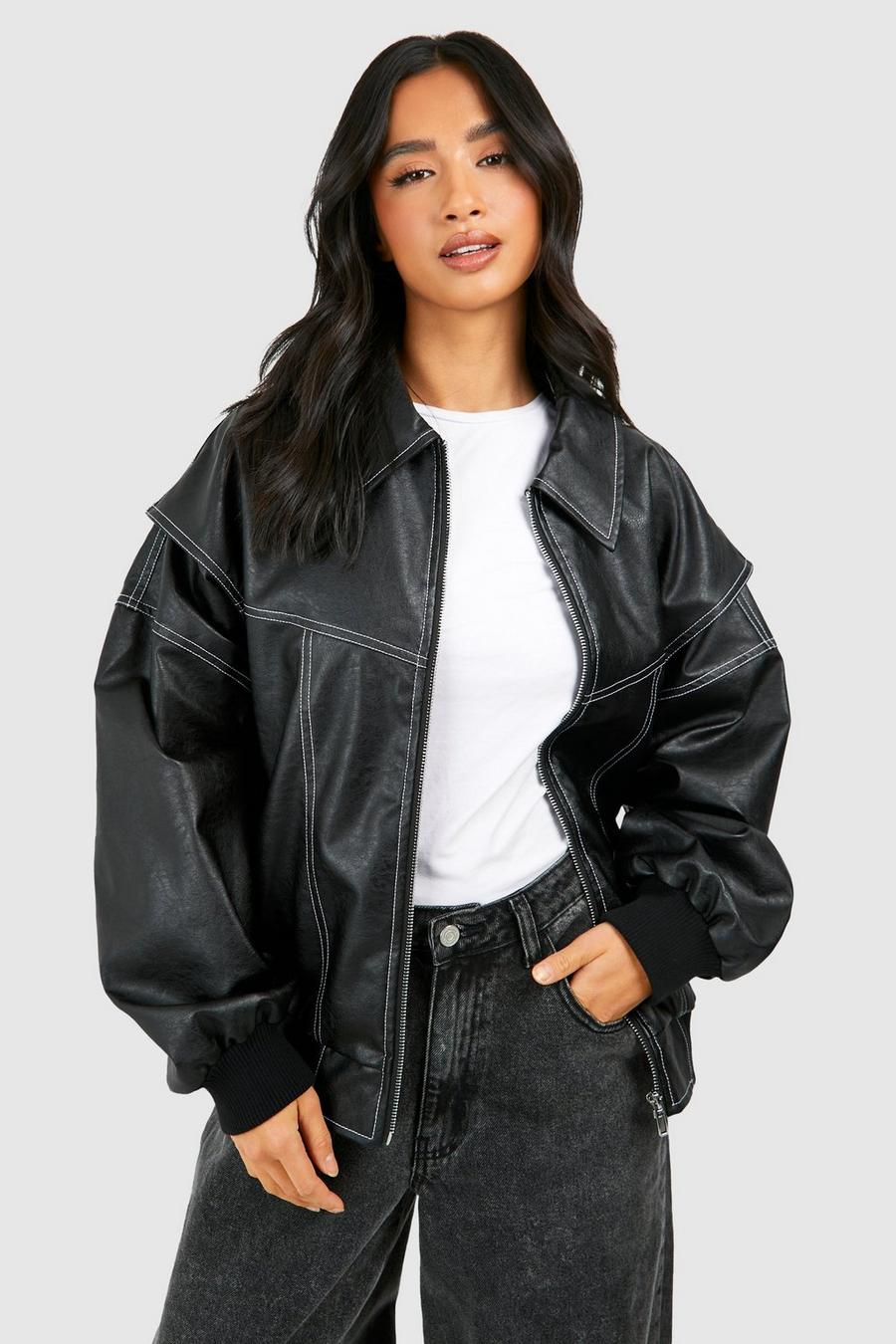 Woman wearing a black classic bomber jacket with contrast white stitching and oversized fit over casual trousers