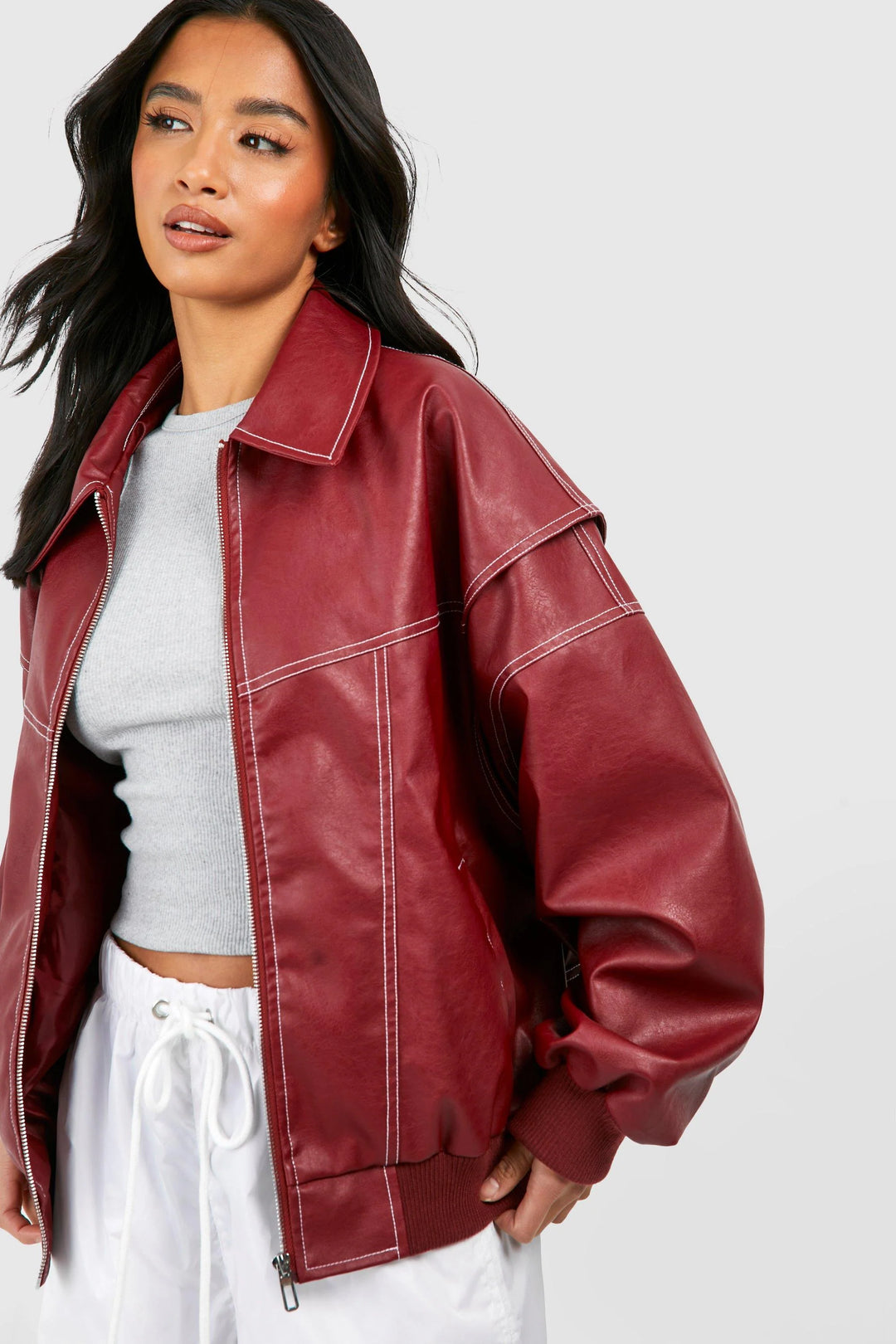 Side view of oversized classic bomber jacket showing dropped shoulders and structured faux leather-look fabric