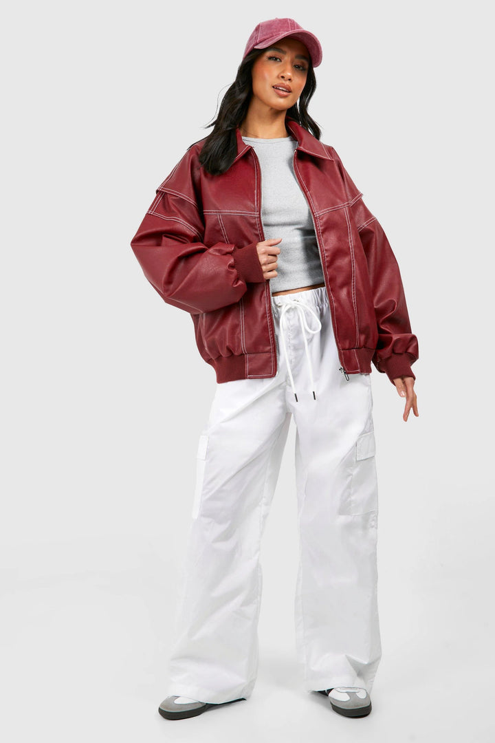Detail shot of contrast white stitching on black classic bomber jacket with ribbed hem