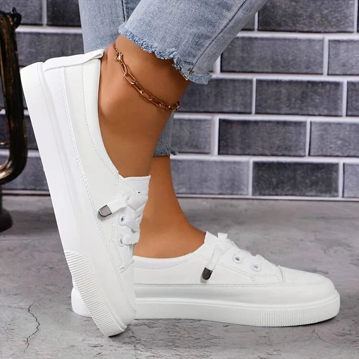 Side view of women's white platform trainers with rounded toe and structured design