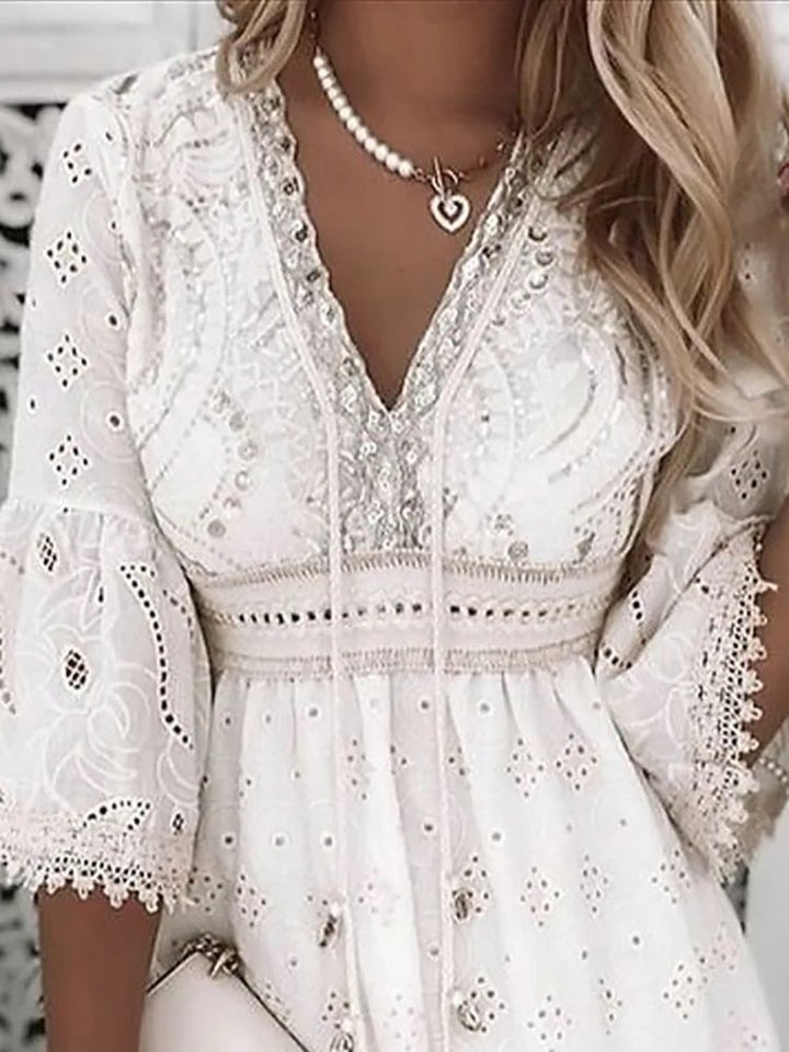 Detail of three-quarter bell sleeves with scalloped lace trim on boho mini dress