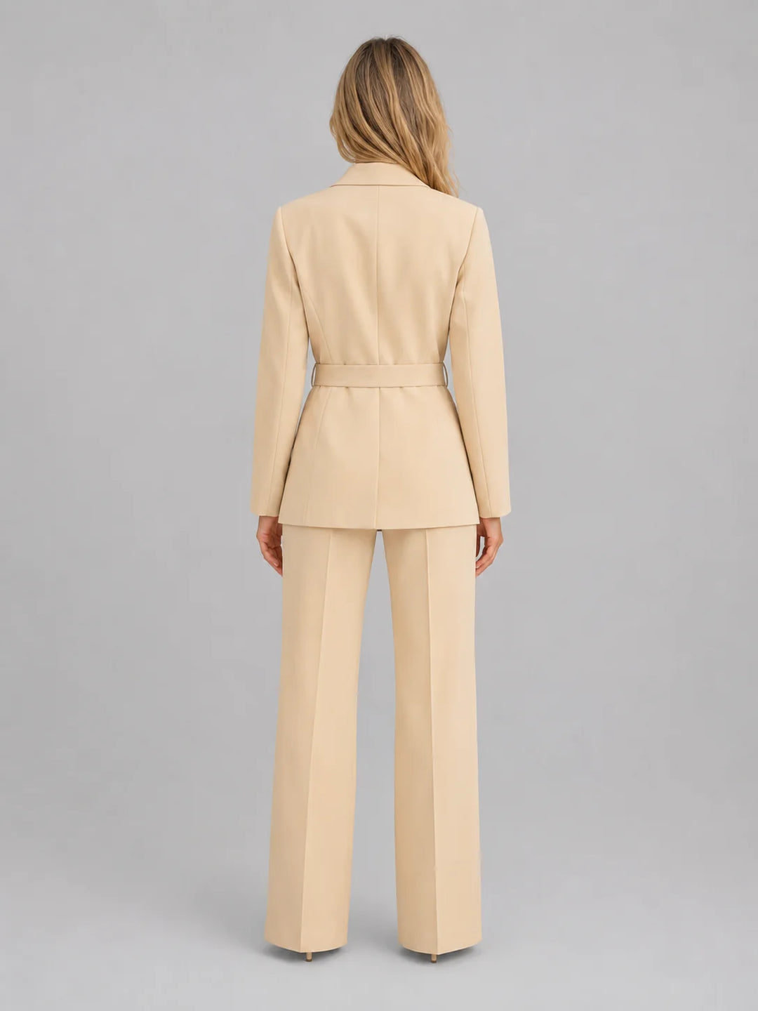 Front view of tailored two-piece suit featuring belted blazer and high-waisted wide leg trousers