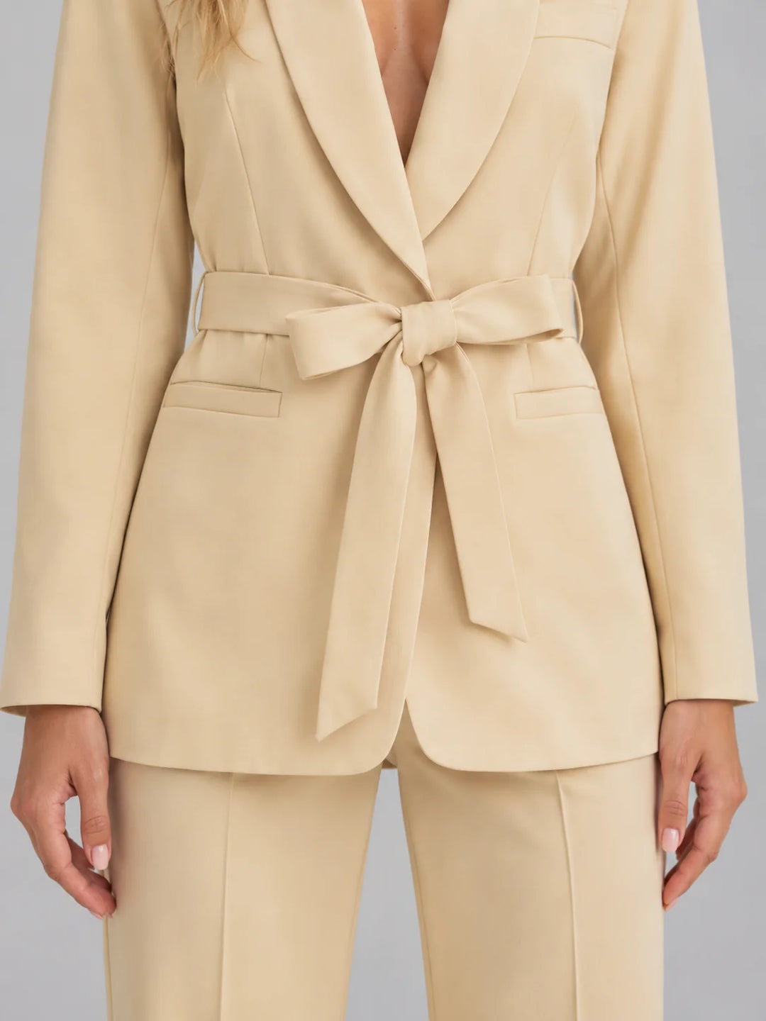 Close-up of shawl collar blazer with adjustable self-tie waist belt and structured fabric