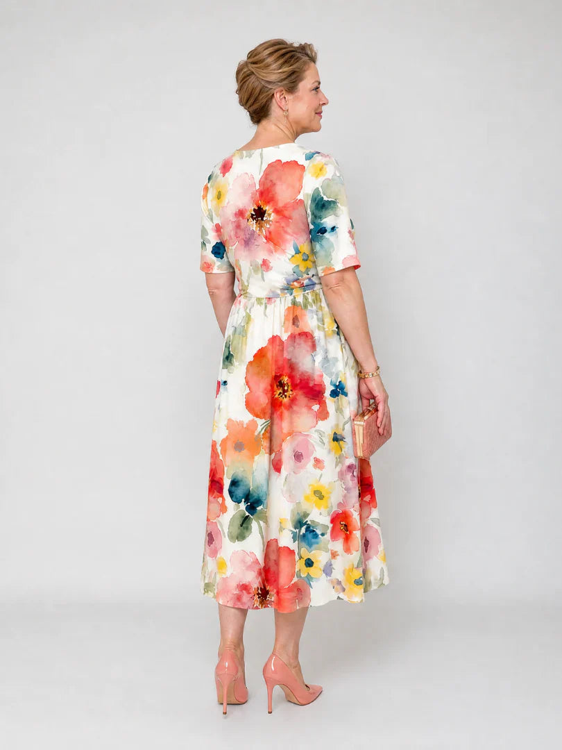Detail shot of floral midi dress fabric with coral, yellow, and teal watercolour blooms