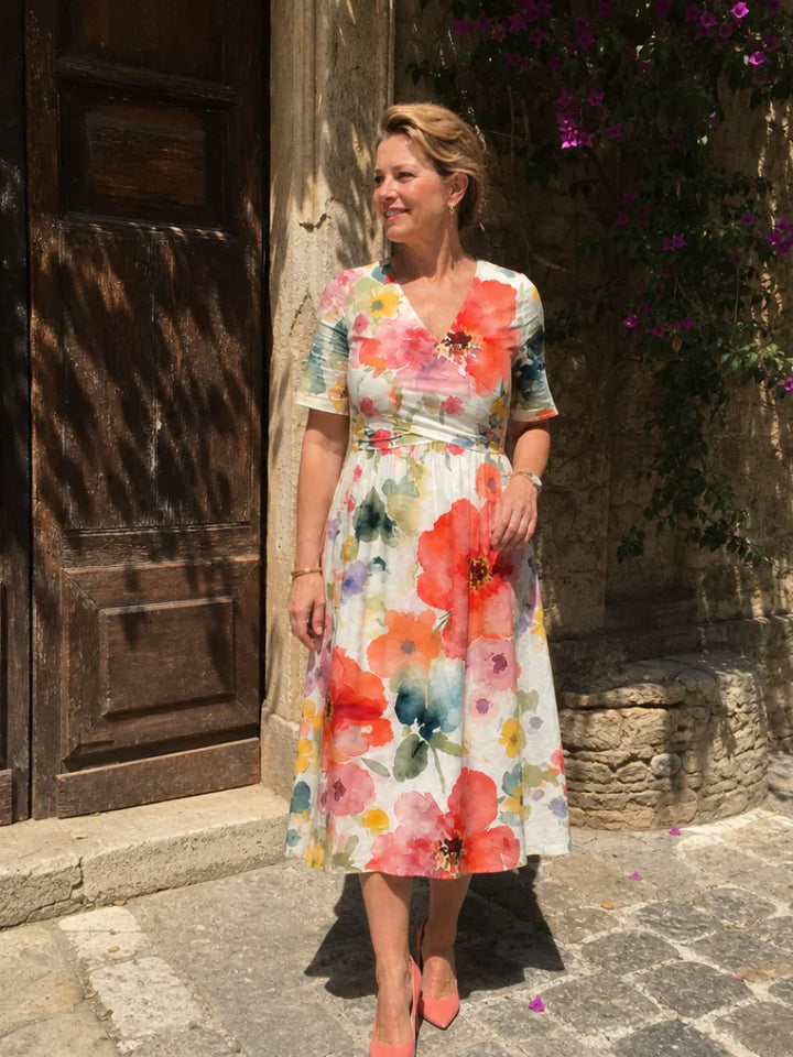 Full-length view of floral midi dress styled with coral heels and coordinating clutch bag