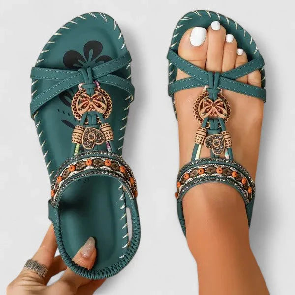 Women's embellished sandals displayed showing secure T-strap design and beaded toe post detailing