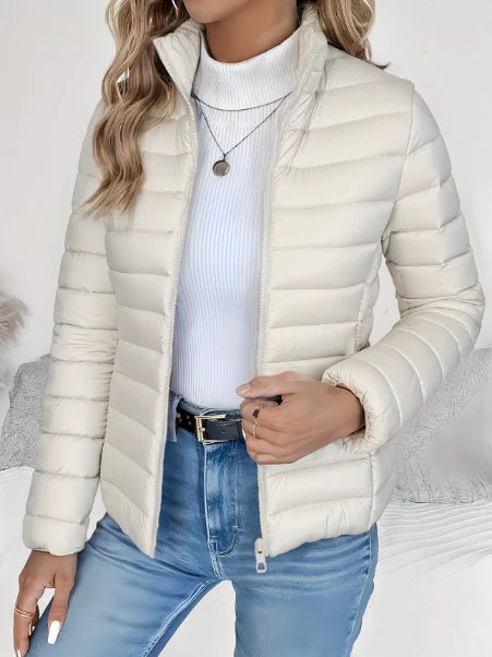 Woman styling the quilted spring jacket with white turtleneck and blue jeans for casual wear