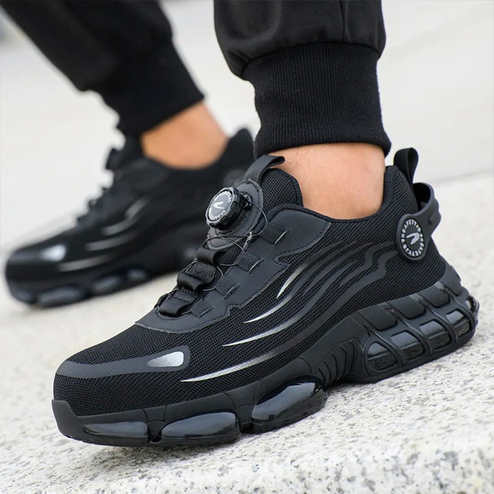 Black safety trainer worn on foot
