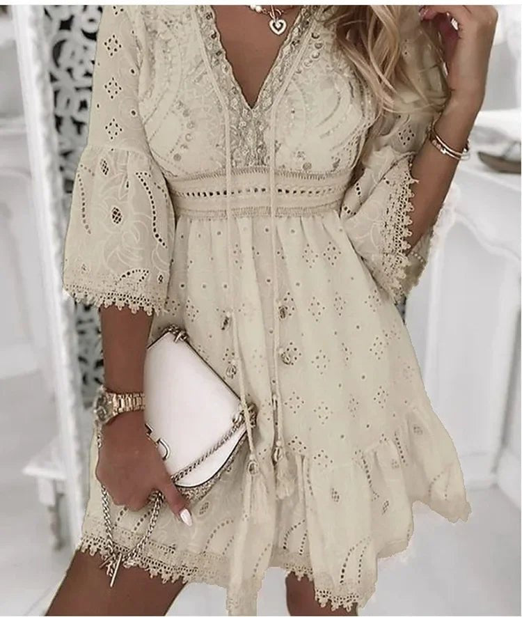 Side angle showing the flowing A-line silhouette and three-quarter length bell sleeves with lace trim on the mini dress