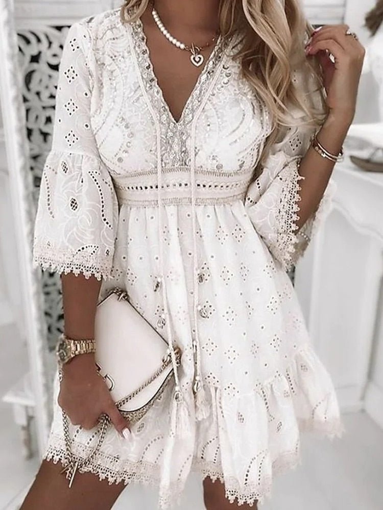 Detail shot of the intricate eyelet lace pattern and bohemian bell sleeve design on the Boho Mini Dress