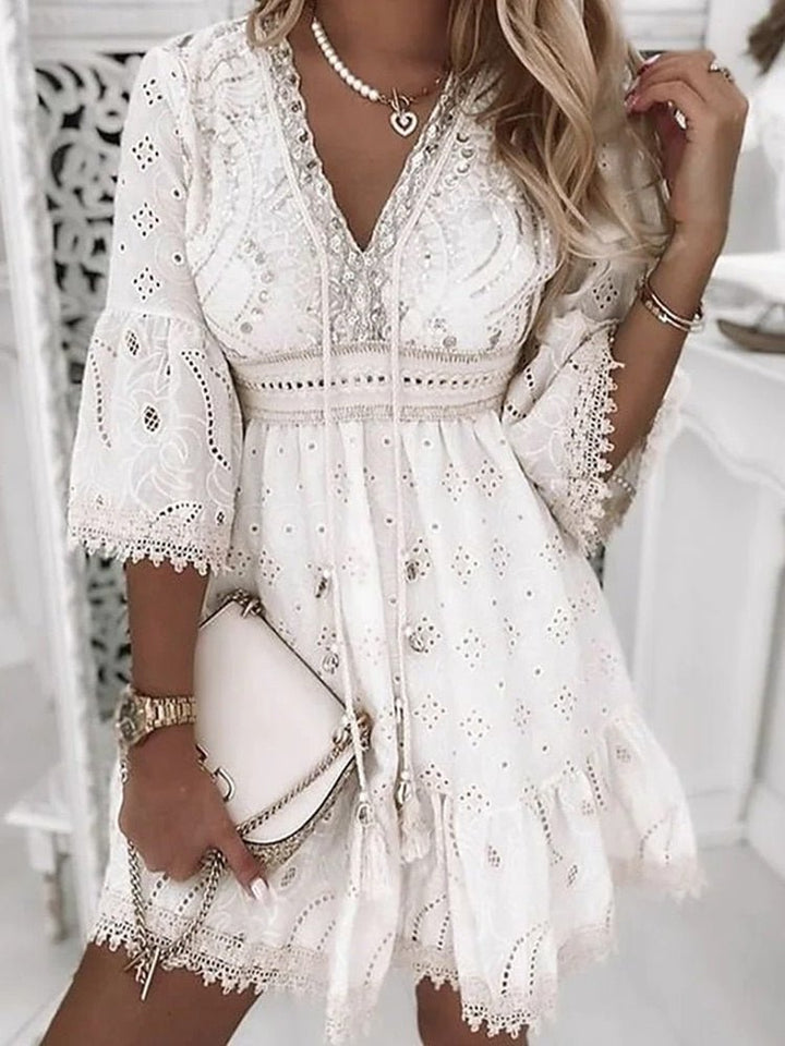 Detail shot of the intricate eyelet lace pattern and bohemian bell sleeve design on the Boho Mini Dress