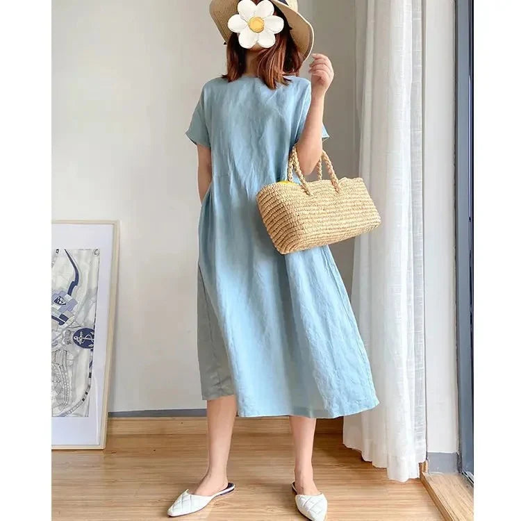 Linen midi dress fabric detail showing soft texture and natural finish in neutral light