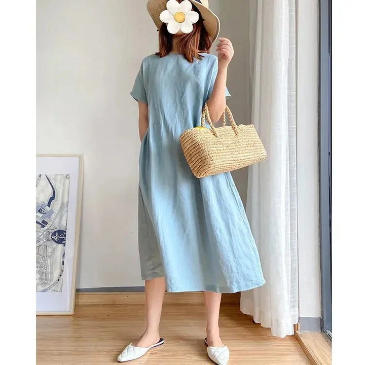 Linen midi dress fabric detail showing soft texture and natural finish in neutral light