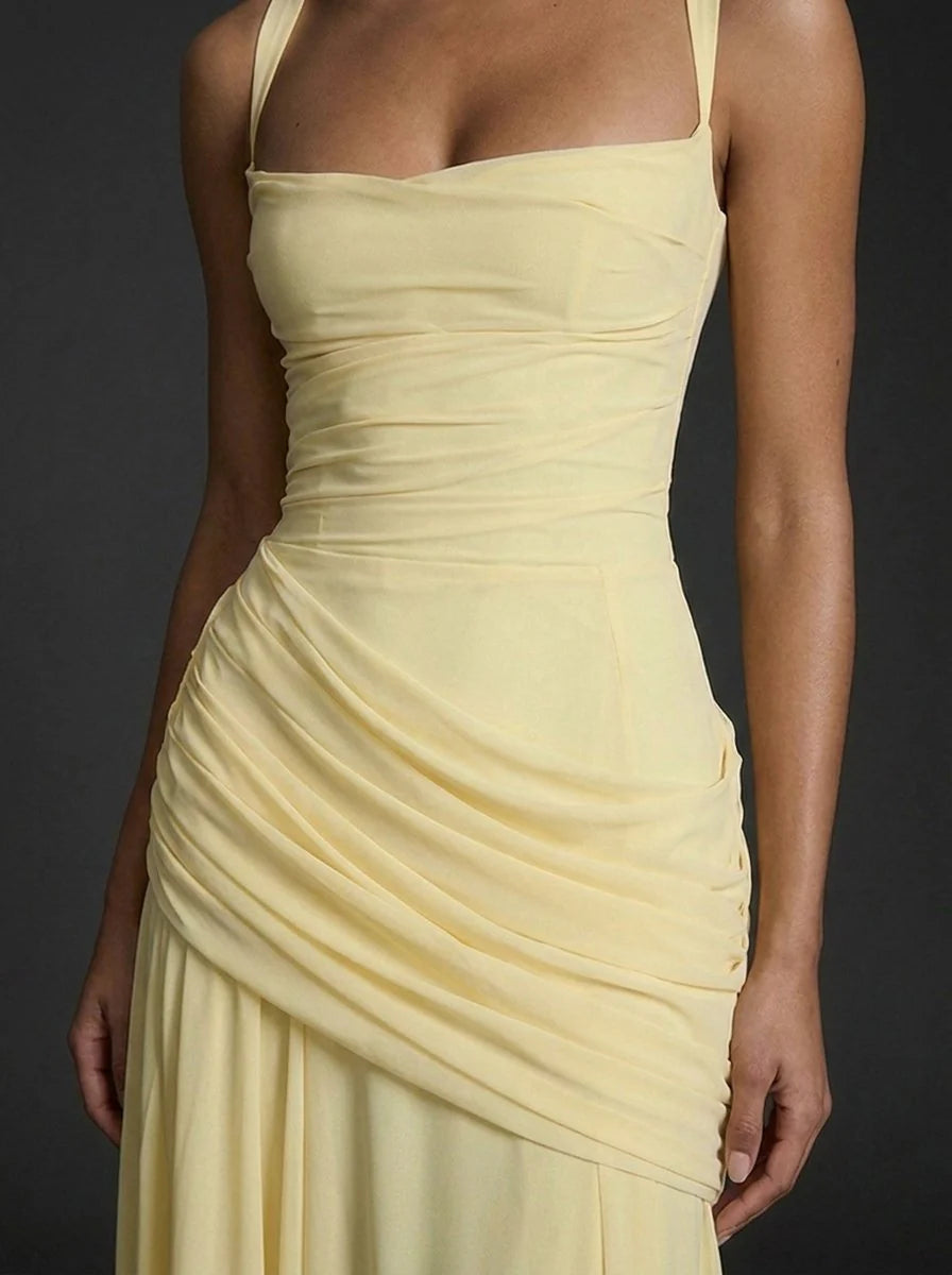 Close-up view of asymmetric ruched detailing on butter yellow maxi dress bodice and hip