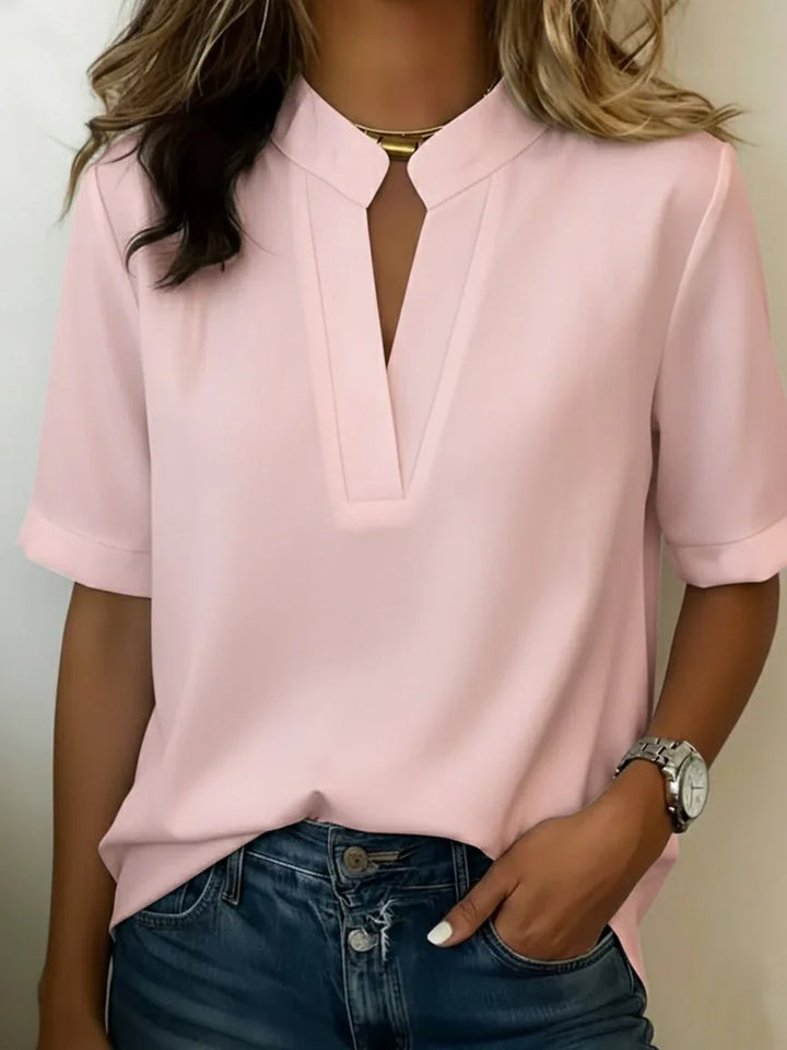 Women's short sleeve blouse in light blue featuring neat rolled cuffs and flowing silhouette