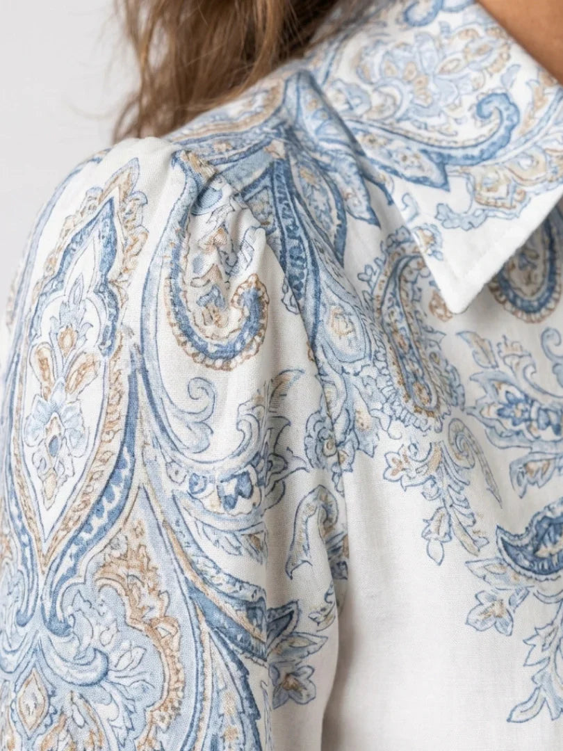 Front view of high neck printed maxi dress showing structured bodice, button-front closure, and flowing skirt with paisley pattern
